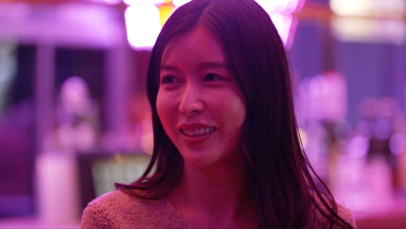 夜の繁華街で笑顔の女性