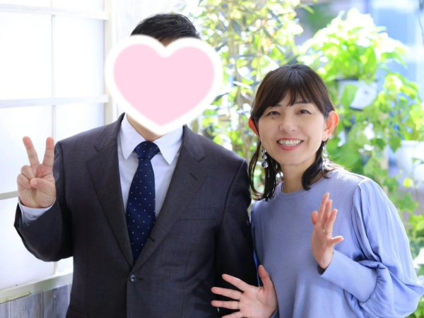 明るい屋内で男女二人が笑顔でポーズをとっている画像