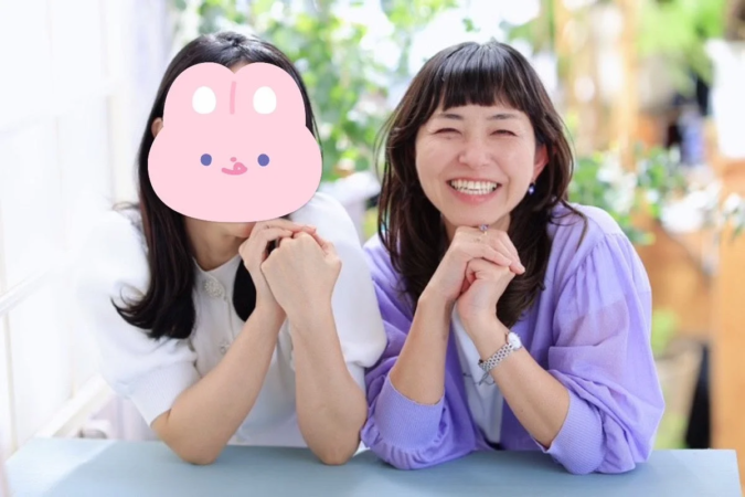 テーブルを挟んで座る2人の女性が写っている画像