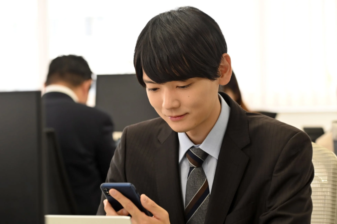 オフィスでスマートフォンを操作する男性