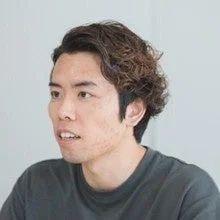 横顔で写る若いアジア人男性の上半身のポートレート
