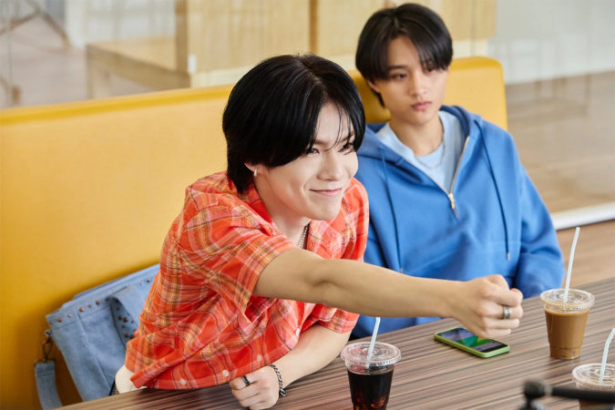 カフェでくつろぐ二人の若い男性が写っています